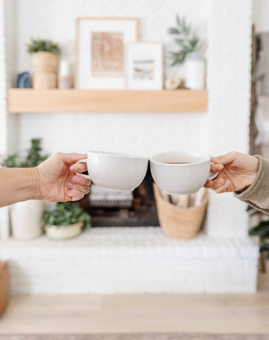 Coffee mug cheers at home in front of fireplace
